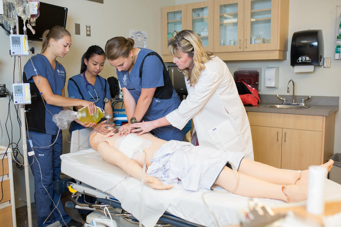 Associate professor, Sandra Goldsworthy, alongside students working with a simulation mannequin.