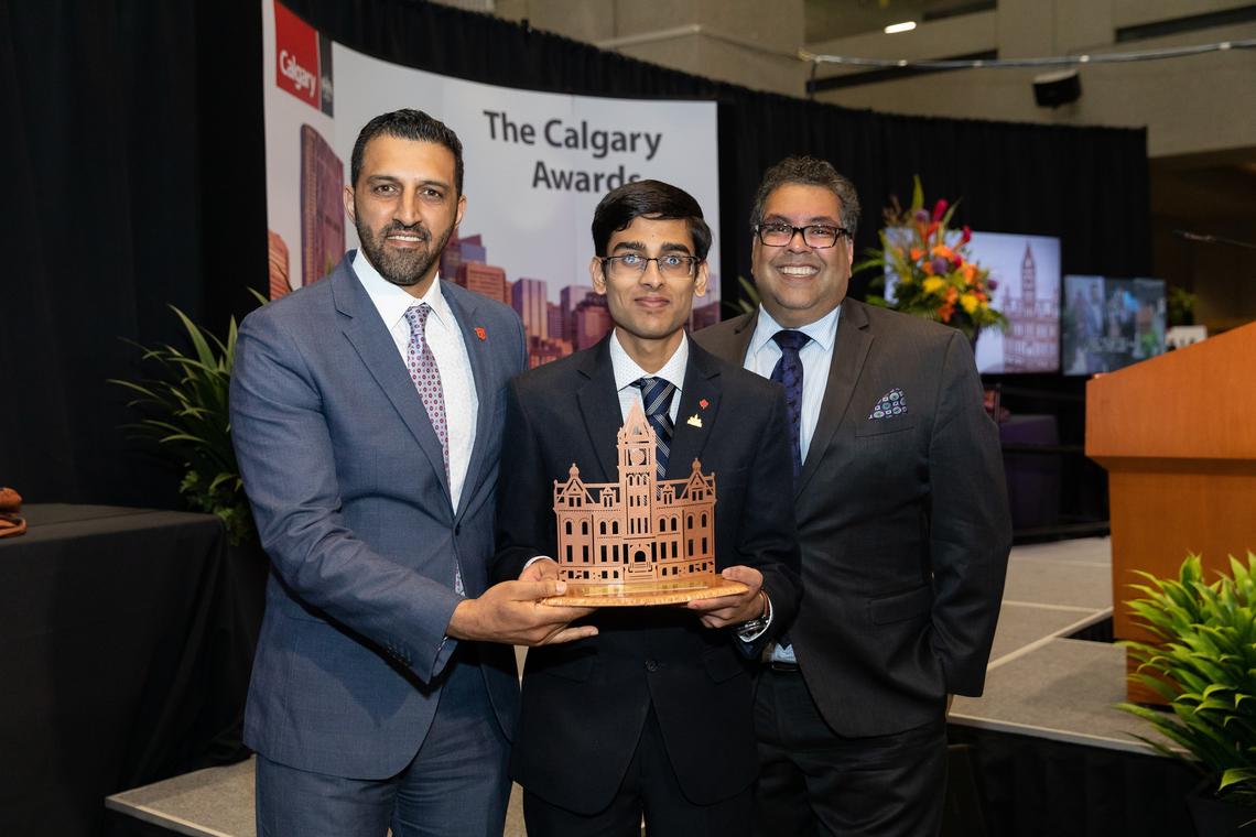 Nihal Potdar, centre, is awarded the UCalgary sponsored Youth Award, presented by Councillor George Chahal, left, and Mayor Naheed Nenshi.  