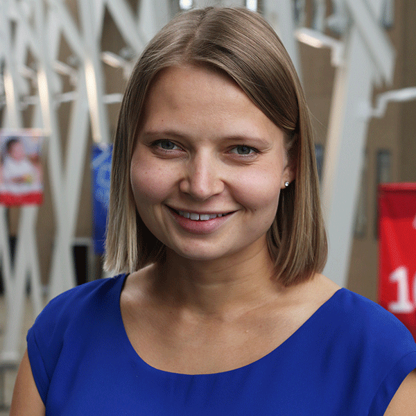 a picture of Jill de Grood indoors smiling in a blue shirt indoors.