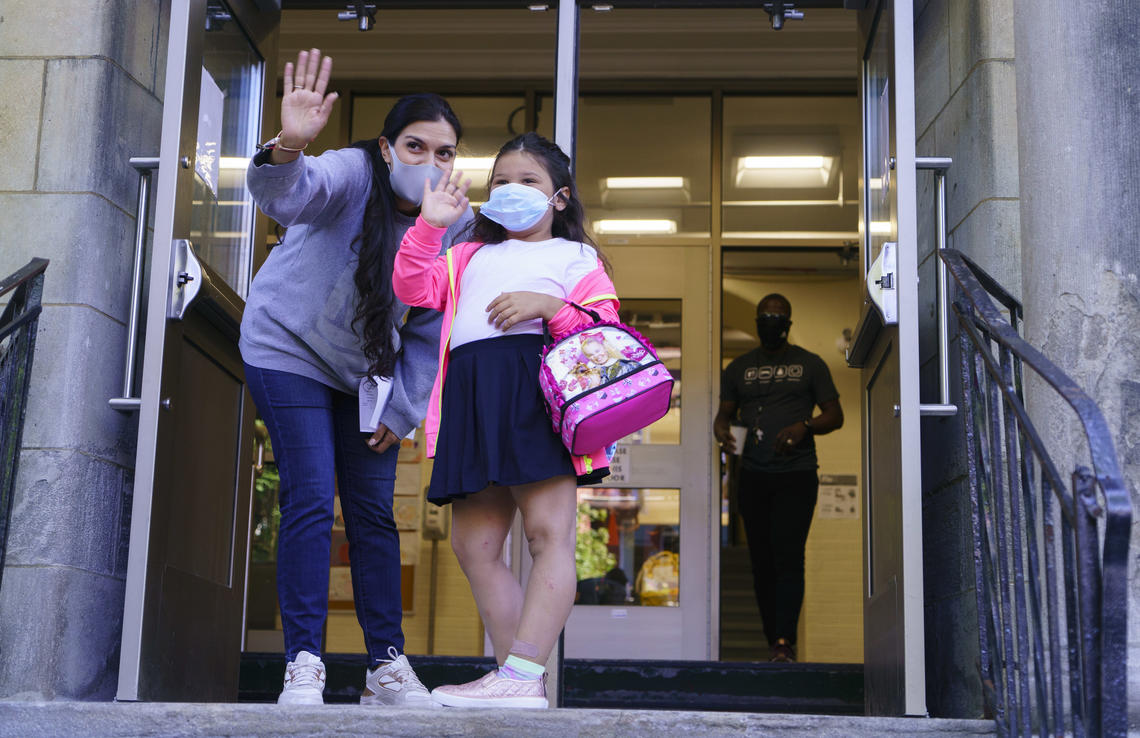 A student waves to her parents as she enters the Bancroft Elementary School as students go back to school in Montréal last August.