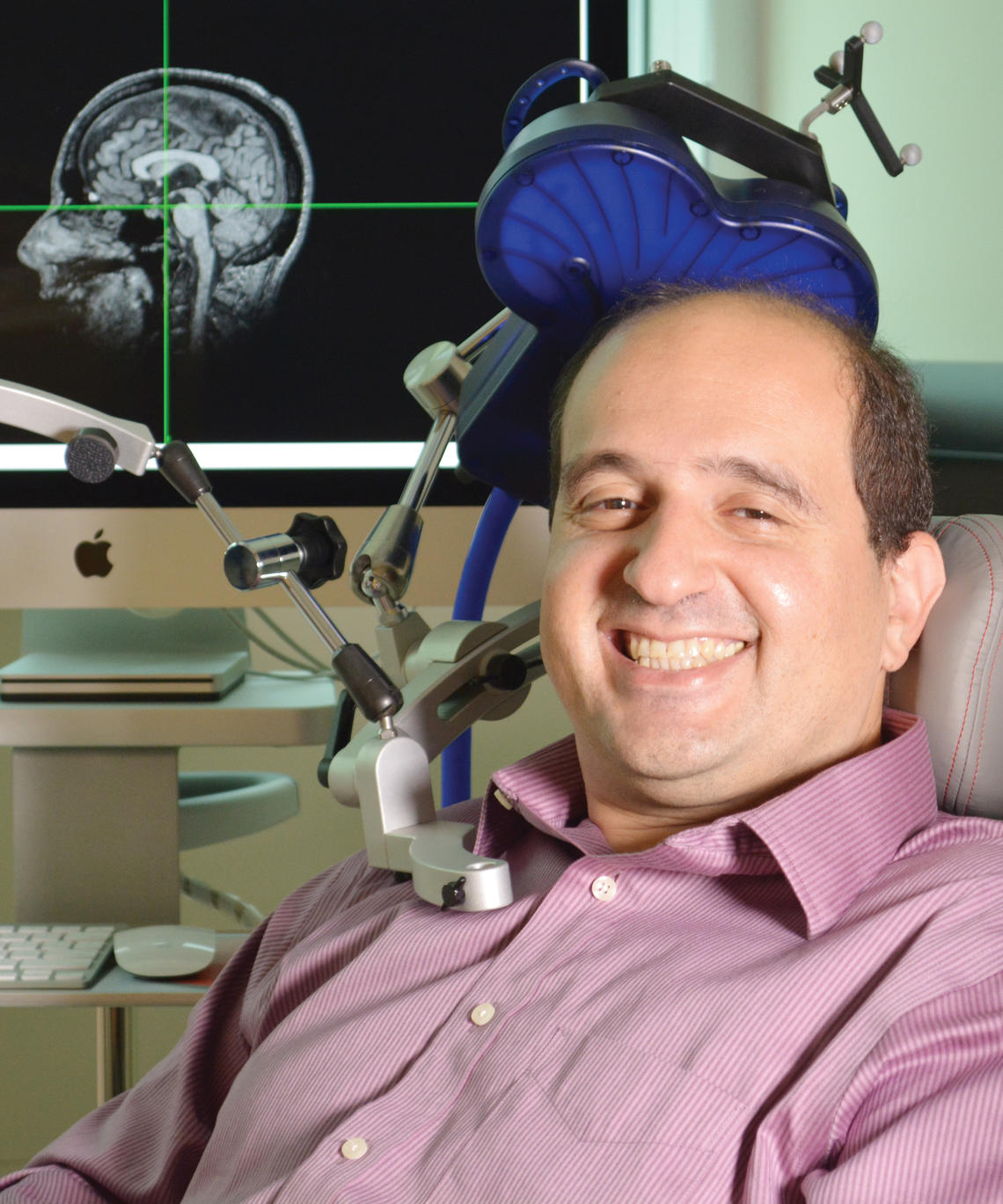 Dr. Oury Monchi with a TMS machine