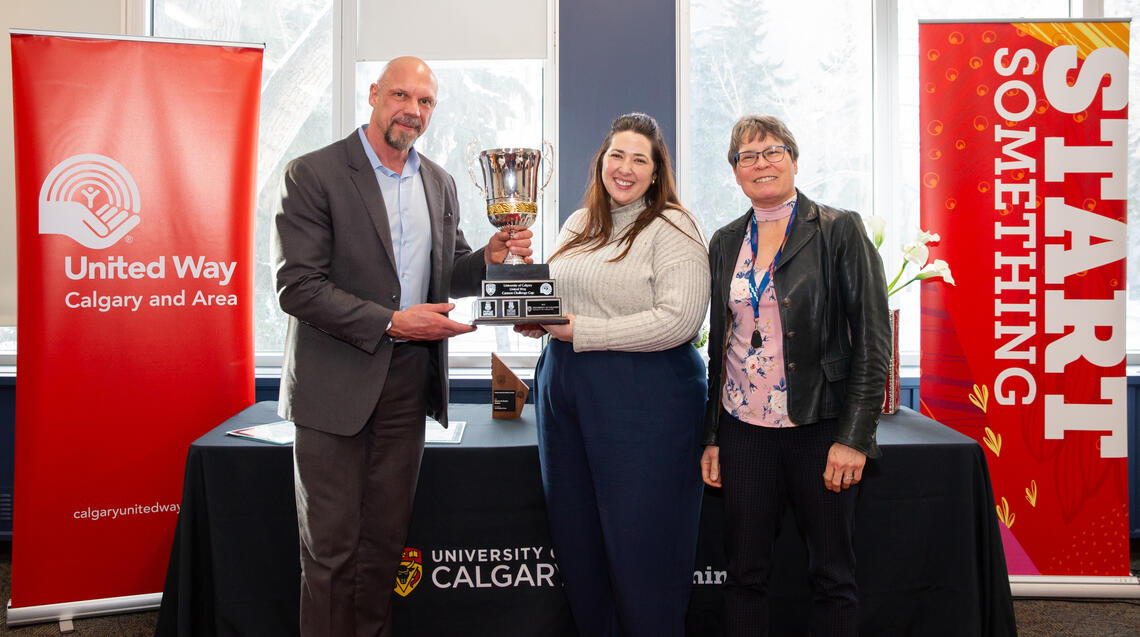 James Allan, VP of Advancement, and Susan Brooke, VP of Community Impact & Partnerships, united Way of Calgary and Area, proudly award the 2023 Cannon Challenge Cup to this year's first-place honorees, Rebecca Trautwein