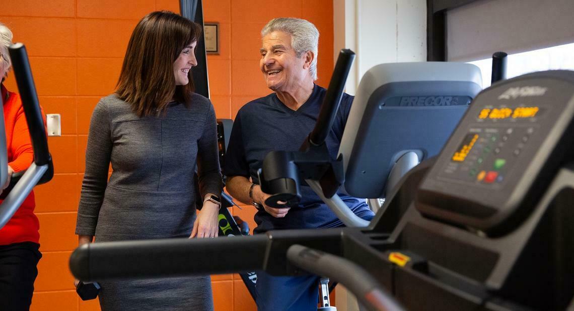 woman and man standing by exercise equipment