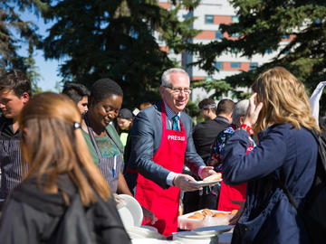 President and Vice-Chancellor, Dr. Ed McCauley hands out buns and talks to students at the President’s Barbeque.