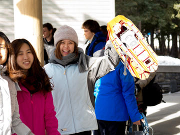 Students hold up snowshoes excitedly