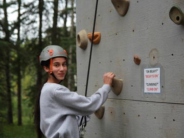 A student ascends the climbing wall