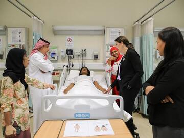 People stand around a hospital bed where a simulation takes place