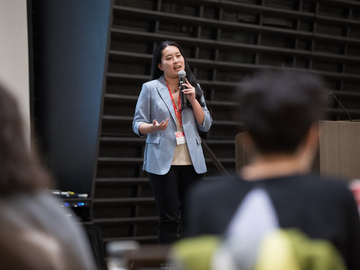 Mengchi stands on stage pitching