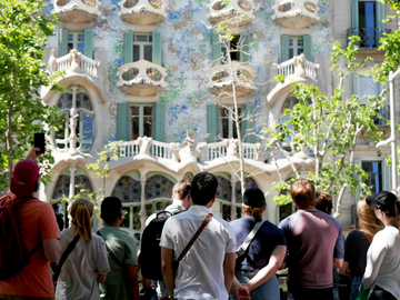 A group of people look at a building covered in vines