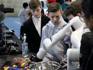 Students at the fair watch Schulich School of Engineering Robotic arm