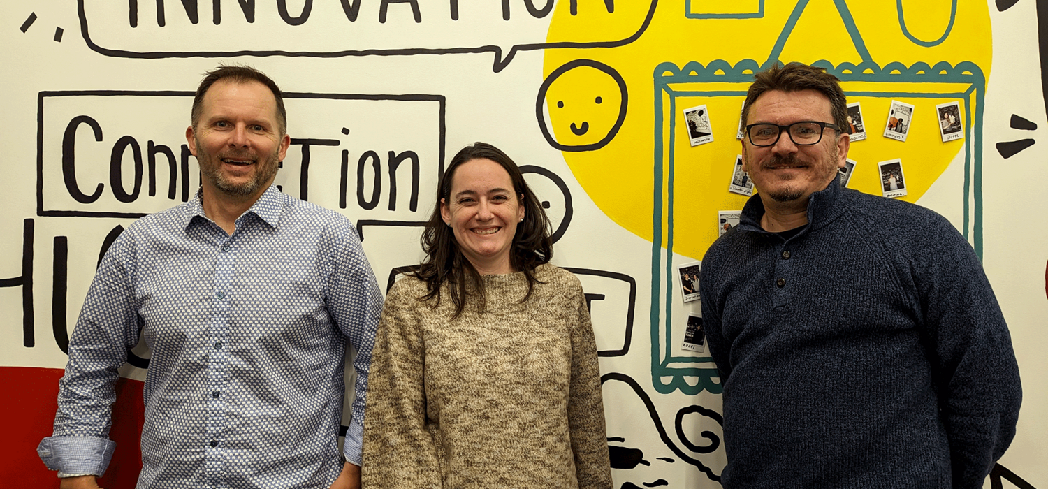 Adam Pidlisecky, Paula Berton and Jagos Radovic stand together smiling in front of a wall that says Innovation