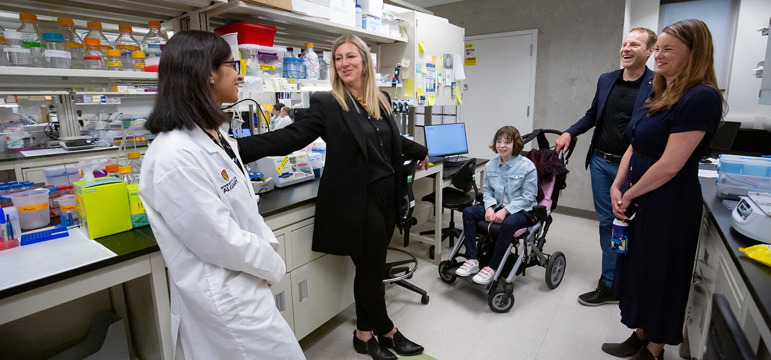 The Walsh family learns about organoid research in the Kurrasch lab. From left: Deepika Dogra, Deborah Kurrasch, Linden Walsh, Ian and Erin Walsh.