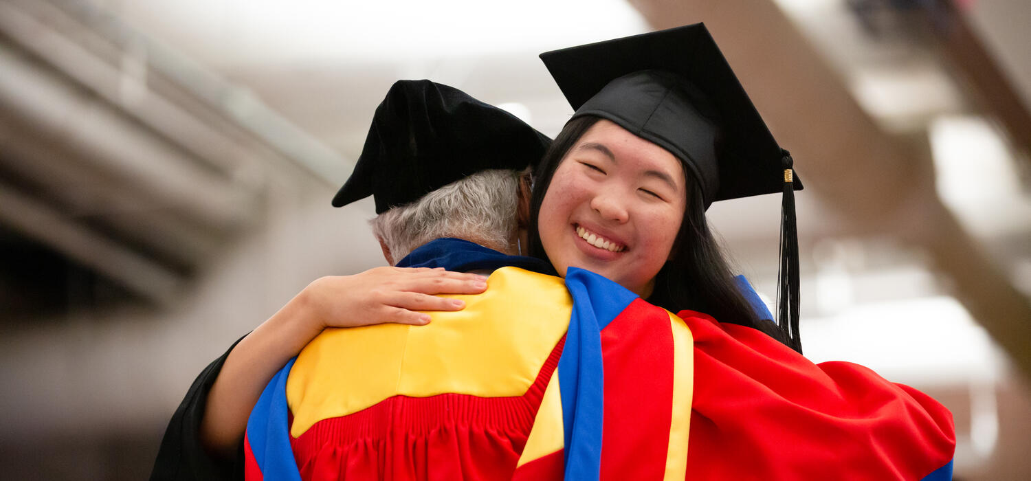 Emily Chen embraces Dick Haskayne at the 2023 Convocation