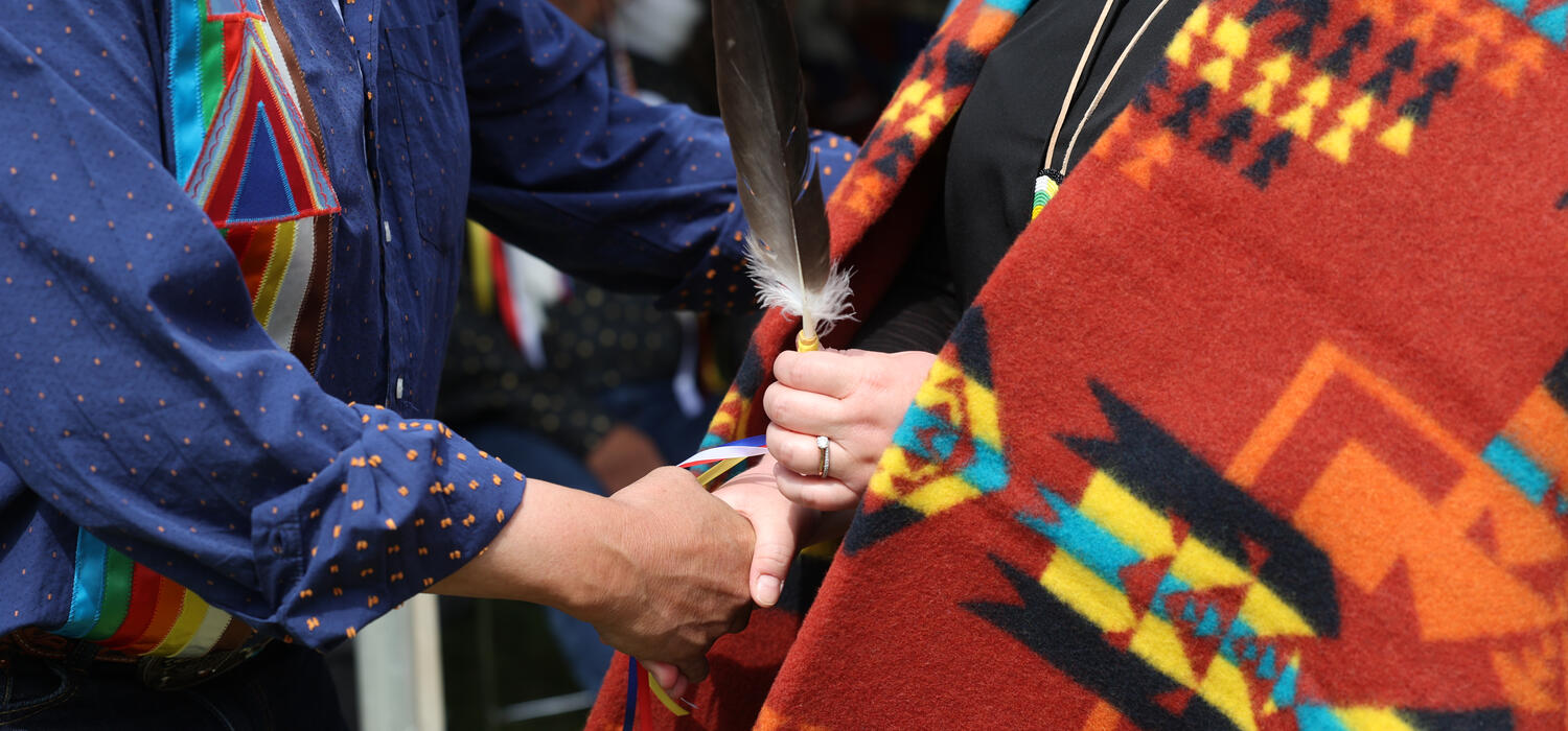 A close up shot of a feather passing at an Indigenous graduation