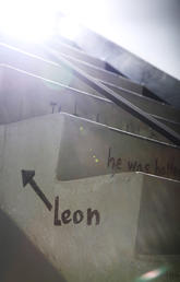 Sideview of the Social Sciences stairs featuring the original Leon the Frog poem. The name "Leon" is writen in black marker, with an arrow pointing upwwards.