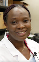 Dr. Ibukun Akinrinade in her lab coat.
