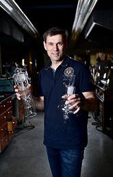 Mark Toonen holding glassware in glass-blowing workshop