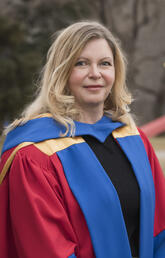 Dr. Marina L. Gavrilova wearing a blue, red, and yellow PhD robe.